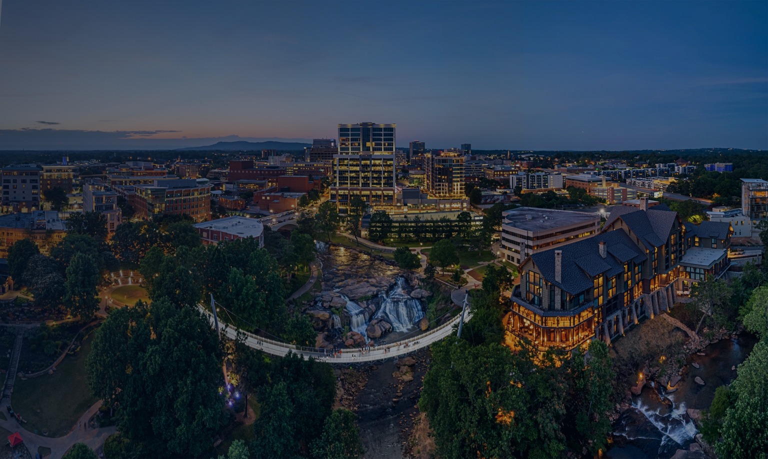 Aerial view of Liberty Bridge over Reedy River Falls in downtown Greenville, South Carolina at sunset